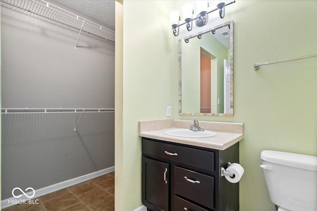 bathroom featuring vanity, tile patterned floors, and toilet