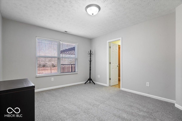 unfurnished room featuring light carpet and a textured ceiling