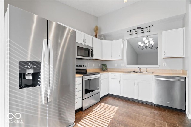 kitchen with sink, decorative light fixtures, white cabinets, and appliances with stainless steel finishes