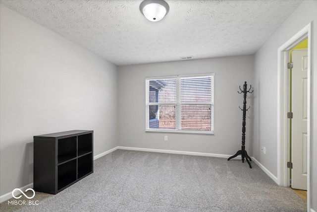 carpeted empty room with a textured ceiling