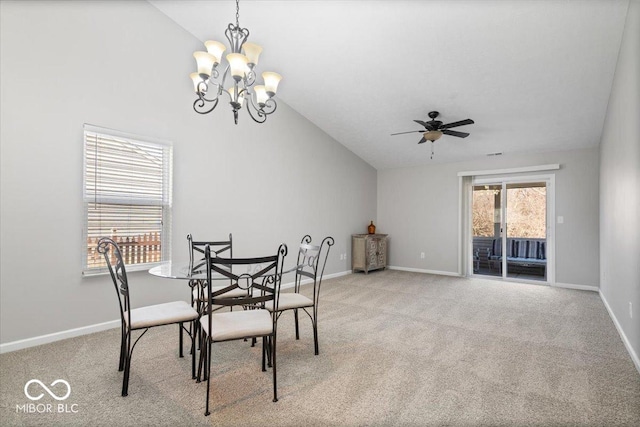 dining area with light colored carpet, lofted ceiling, and ceiling fan with notable chandelier