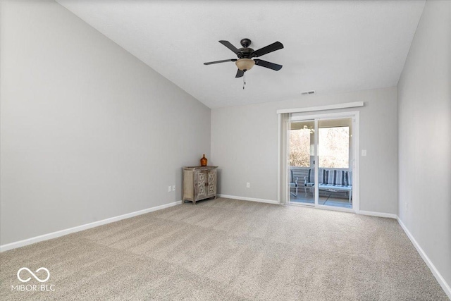 empty room with ceiling fan, light colored carpet, and vaulted ceiling