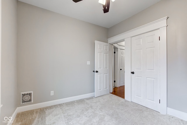 unfurnished bedroom with light colored carpet and ceiling fan