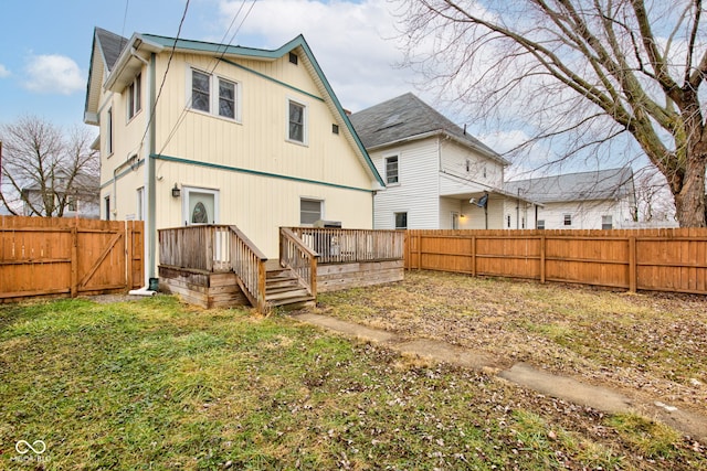 rear view of property featuring a yard and a deck