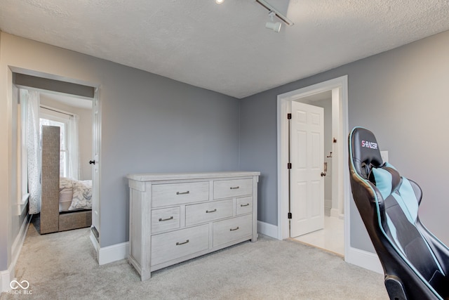 office area featuring light carpet, rail lighting, and a textured ceiling