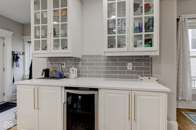 bar featuring white cabinetry, backsplash, hardwood / wood-style floors, and beverage cooler