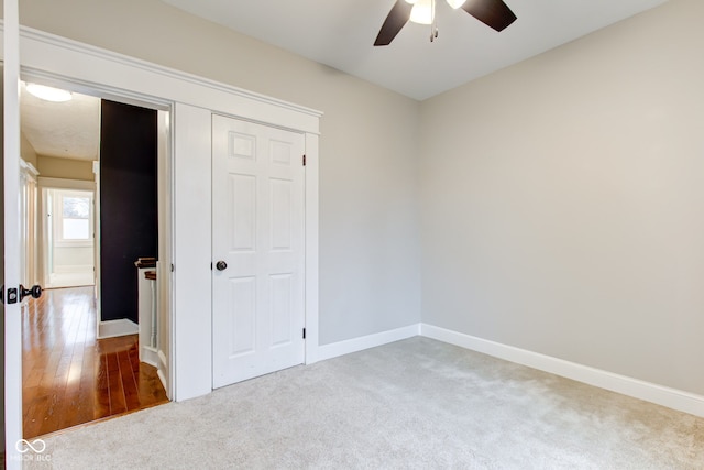 unfurnished bedroom featuring carpet, ceiling fan, and a closet