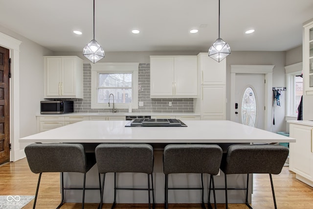 kitchen featuring a large island, sink, stainless steel appliances, and white cabinets