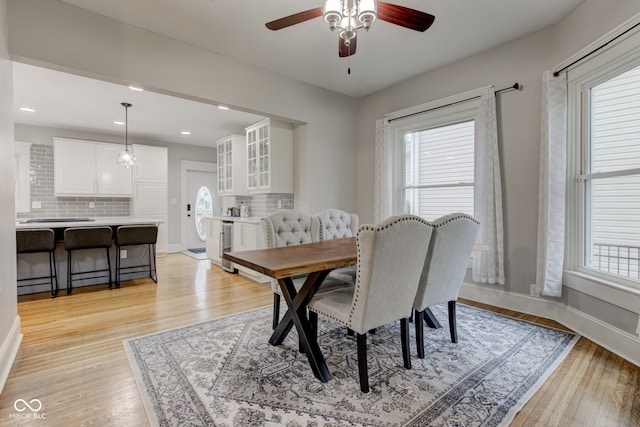 dining space with ceiling fan, beverage cooler, and light hardwood / wood-style floors