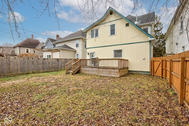 back of house with a wooden deck and a yard