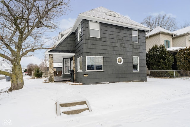 exterior space with fence and roof with shingles