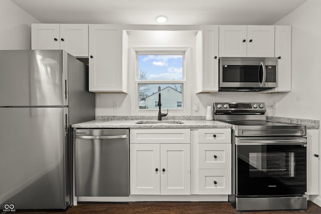 kitchen featuring stainless steel appliances, sink, and white cabinets