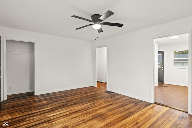 unfurnished bedroom with dark hardwood / wood-style floors, ceiling fan, and a closet