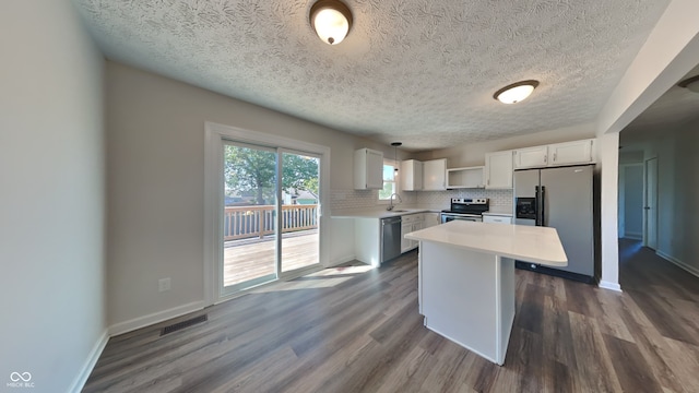 kitchen featuring sink, white cabinets, hanging light fixtures, a center island, and stainless steel appliances