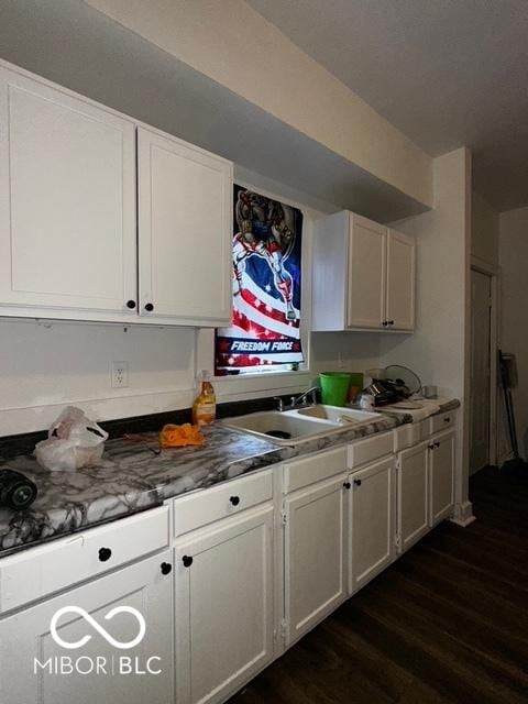 kitchen with dark hardwood / wood-style floors, sink, and white cabinets