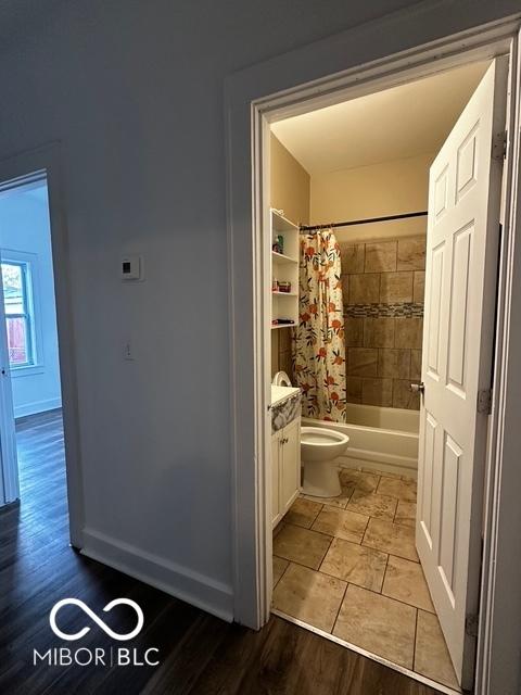 full bathroom with toilet, vanity, shower / bathtub combination with curtain, and wood-type flooring