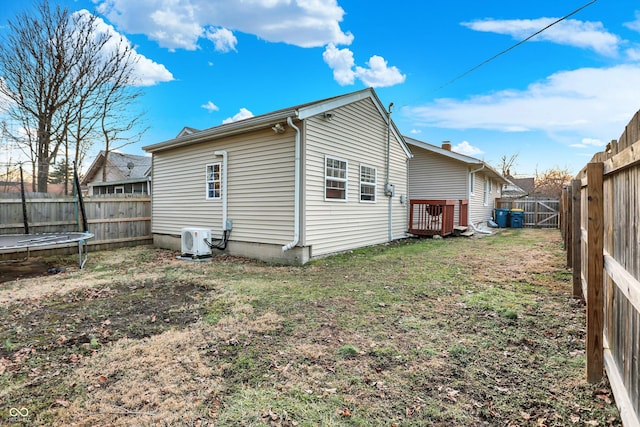 back of house featuring a lawn, a trampoline, and ac unit