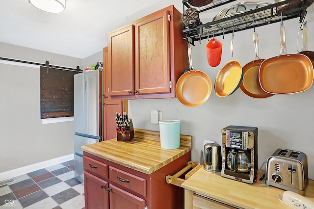 kitchen with a barn door and stainless steel fridge