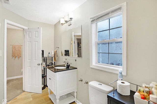 bathroom featuring vanity, toilet, and hardwood / wood-style floors