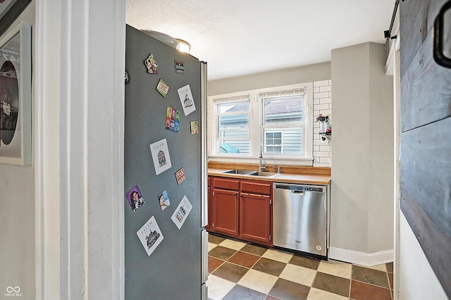 kitchen with stainless steel appliances, butcher block counters, and sink