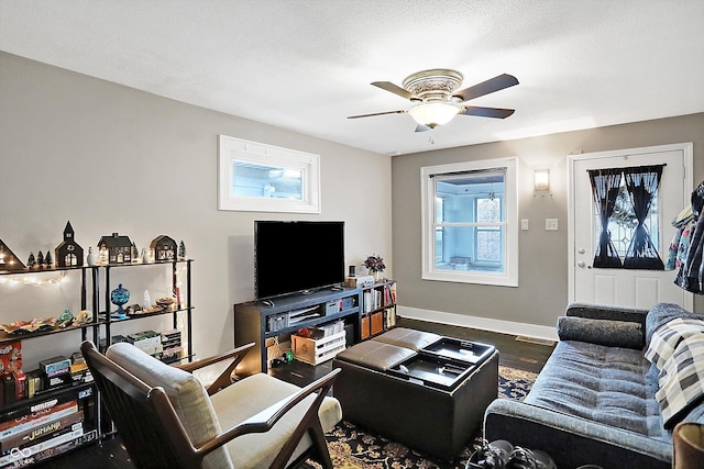 living room with ceiling fan, hardwood / wood-style flooring, a textured ceiling, and a healthy amount of sunlight