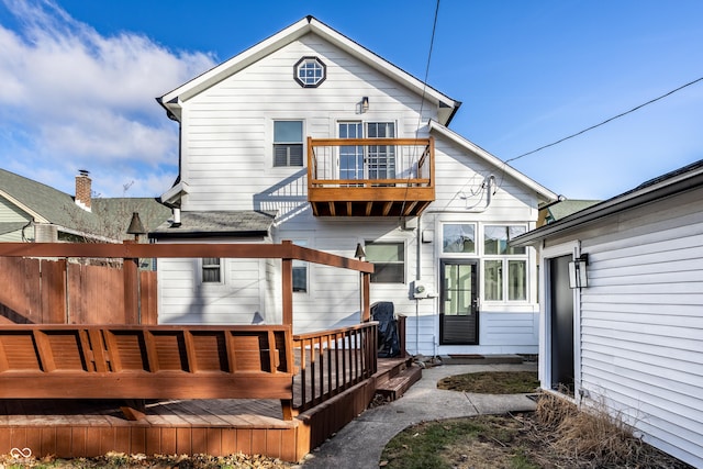 rear view of house with a wooden deck and a balcony