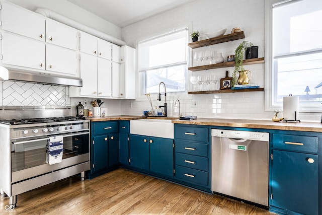 kitchen with stainless steel appliances, white cabinetry, sink, and blue cabinets