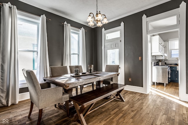 dining room featuring crown molding, hardwood / wood-style floors, and a chandelier