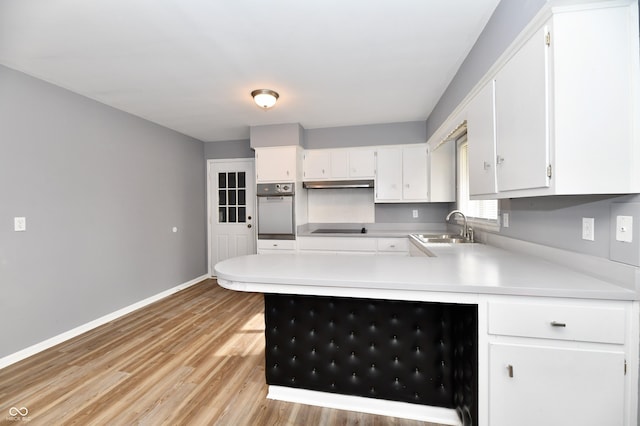 kitchen with sink, white cabinetry, black electric stovetop, light hardwood / wood-style floors, and stainless steel oven