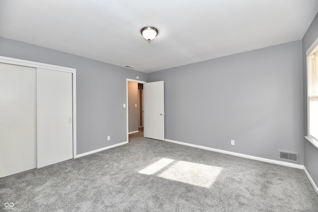 unfurnished bedroom featuring carpet floors and a closet