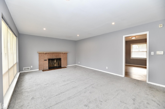 unfurnished living room with a brick fireplace and carpet floors