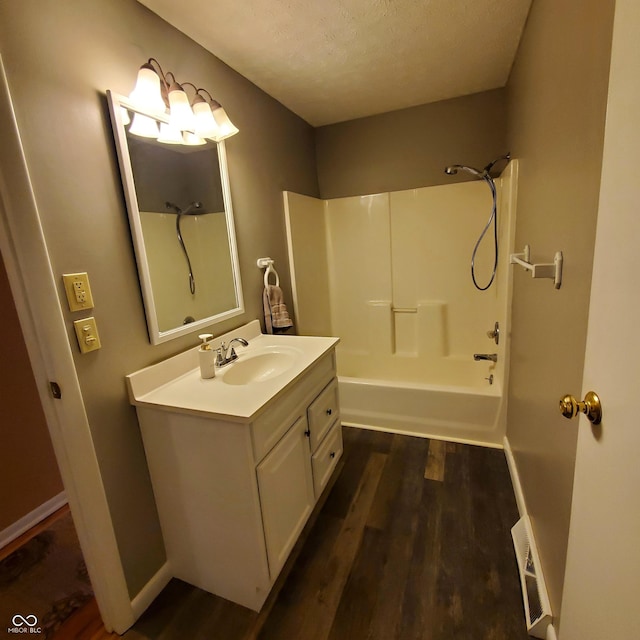 bathroom with visible vents, shower / washtub combination, wood finished floors, and vanity