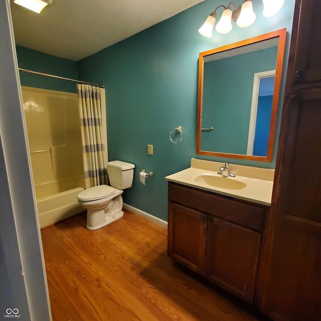 full bathroom featuring toilet, wood finished floors, vanity, baseboards, and shower / bath combo