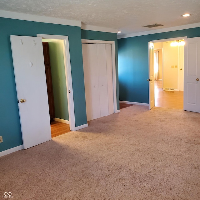 unfurnished bedroom featuring a closet, carpet flooring, a textured ceiling, and baseboards