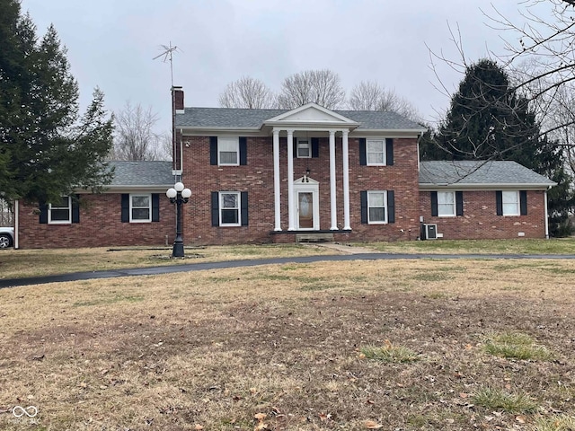 greek revival inspired property with cooling unit and a front lawn