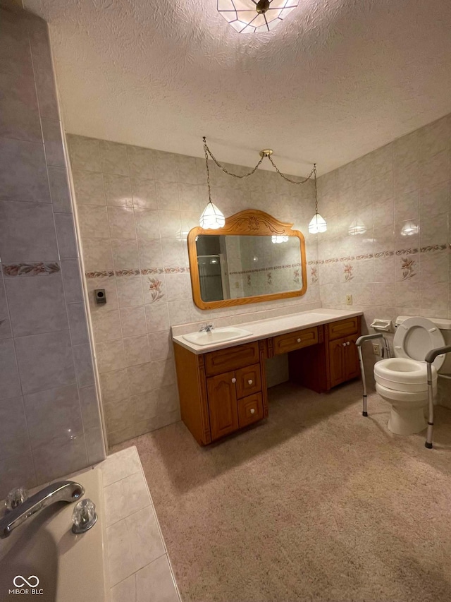 bathroom with tile walls, tile patterned flooring, vanity, a textured ceiling, and toilet