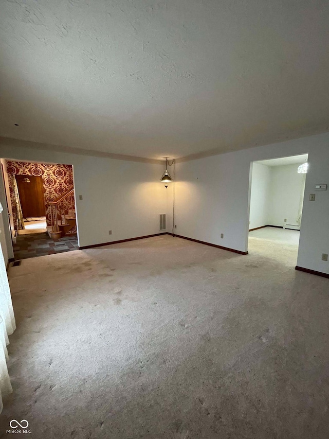 unfurnished room featuring carpet floors and a textured ceiling