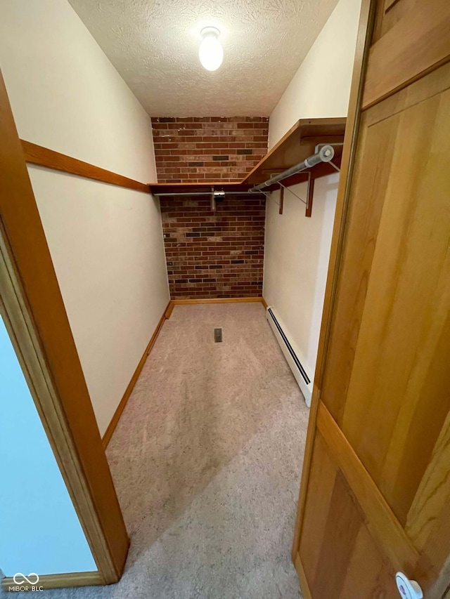 walk in closet featuring baseboard heating and light carpet