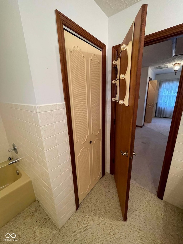 hallway featuring tile walls