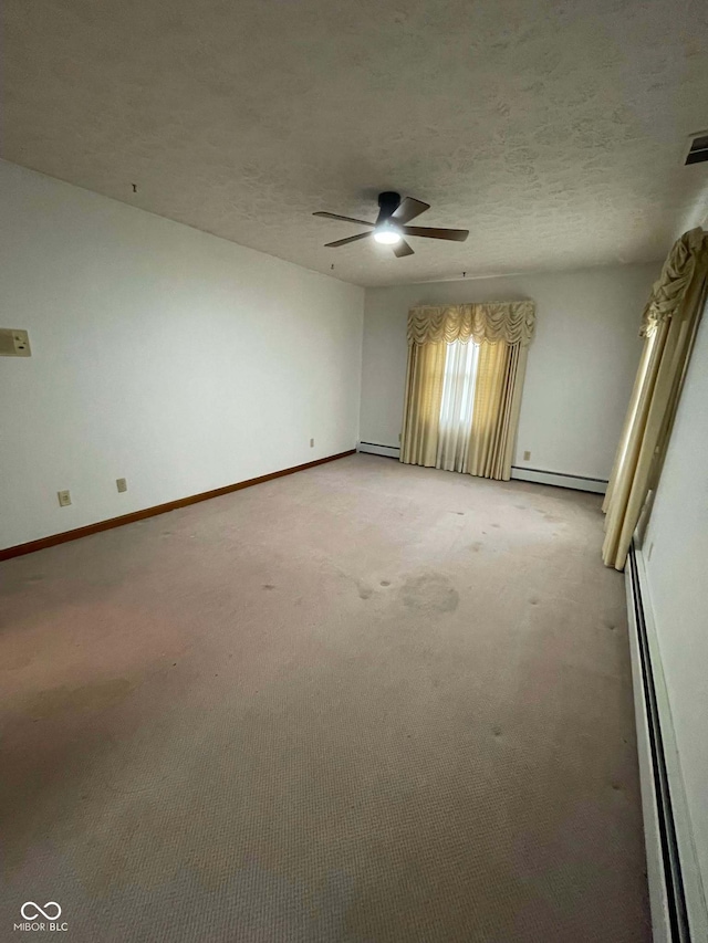 carpeted spare room featuring a baseboard radiator, ceiling fan, and a textured ceiling