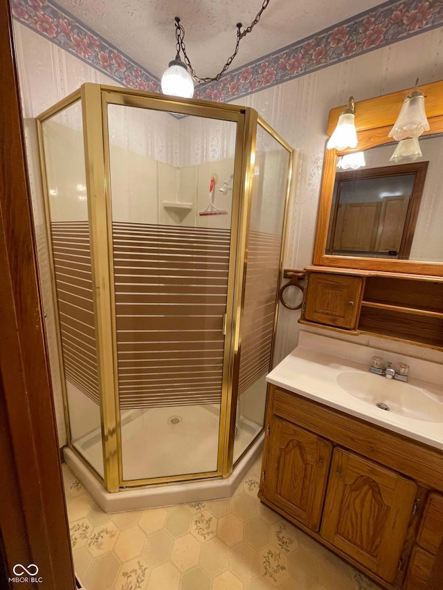 bathroom featuring vanity, a textured ceiling, and a shower with shower door