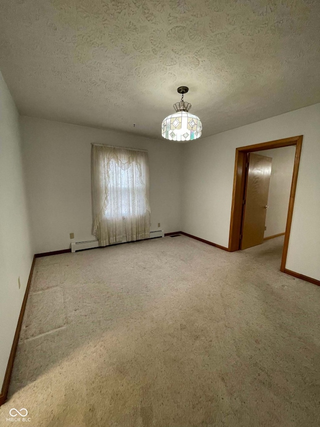 carpeted empty room featuring a baseboard radiator and a textured ceiling