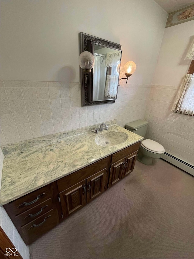 bathroom with vanity, tile walls, a baseboard radiator, and toilet