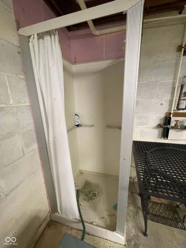 bathroom with a shower with curtain and concrete flooring