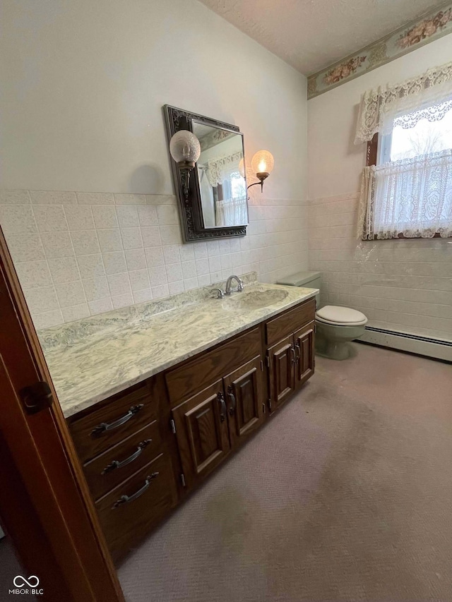 bathroom with toilet, tile walls, a textured ceiling, baseboard heating, and vanity