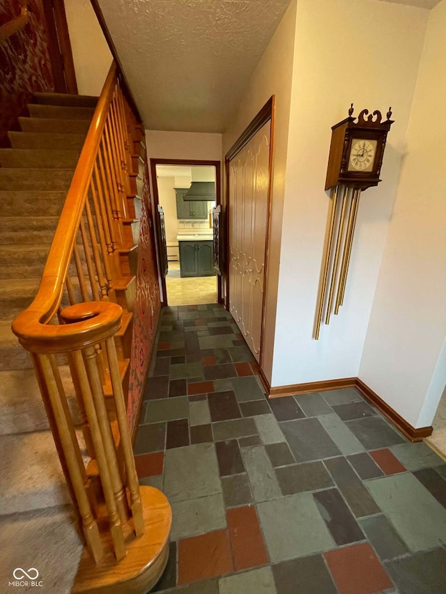 hall featuring a textured ceiling