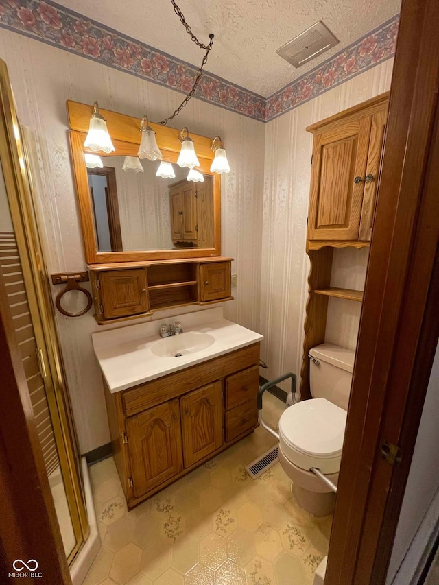 bathroom with vanity, a textured ceiling, and toilet