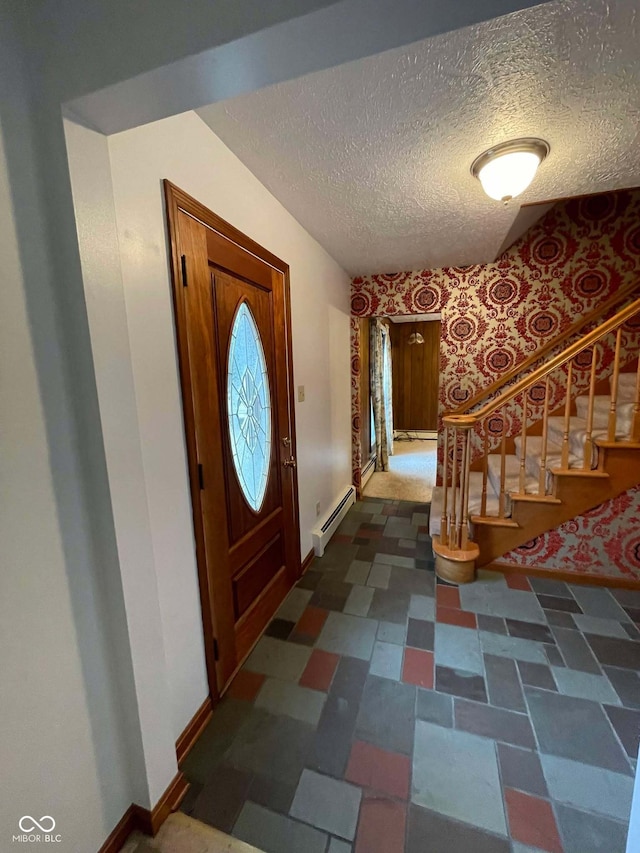 foyer featuring a textured ceiling and baseboard heating