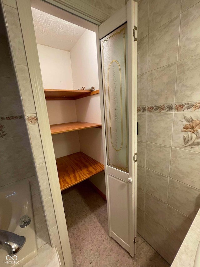 bathroom featuring a tile shower and a textured ceiling