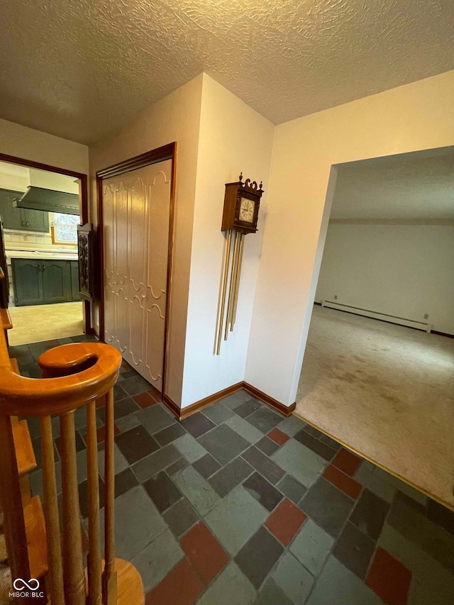 corridor with dark carpet, a baseboard radiator, and a textured ceiling